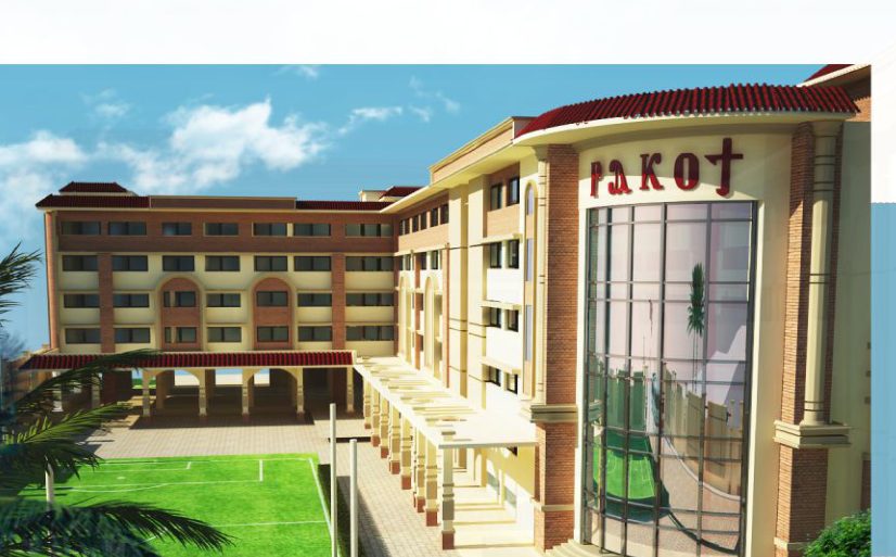 school exterior hero with central glass tower and green lawn